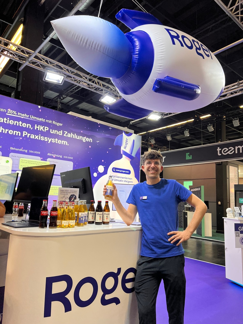 Aufblasbare Rakete mit Logo schwebt als Deckenhänger über einem Messestand